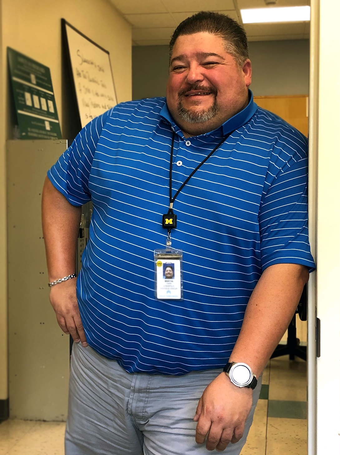 A smiling man leaning against a wall