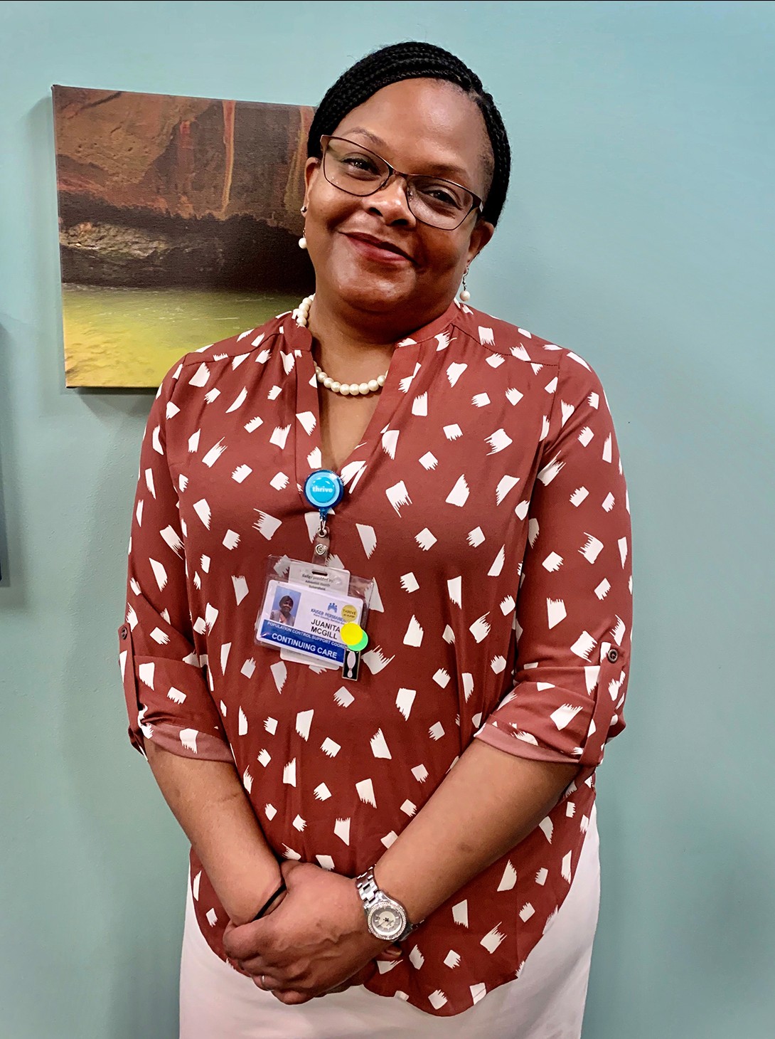 A woman wearing a brown blouse, smiling sweetly