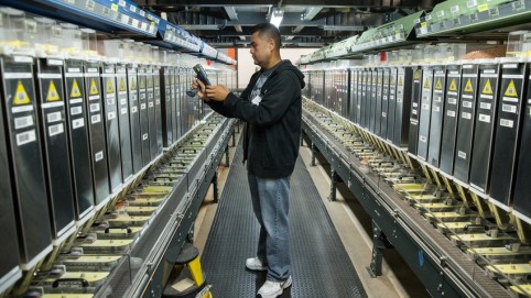 Pharmacy technician amid bins of pills at the Central Refill Pharmacy