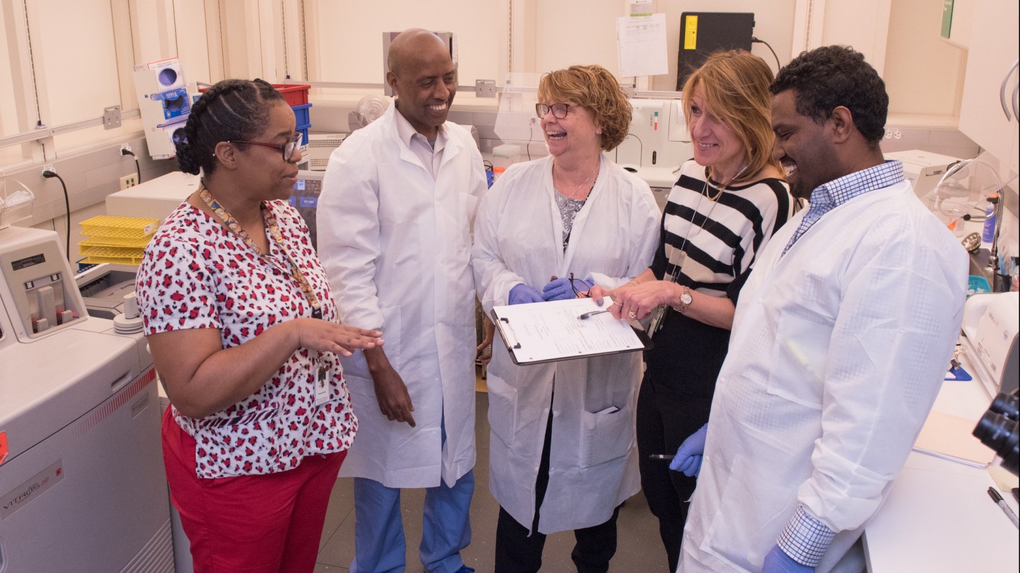 A group of health care workers conferring around a document 